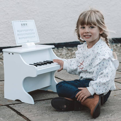 White piano with scores